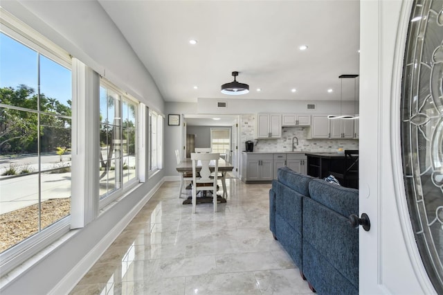 living area with recessed lighting, visible vents, and baseboards