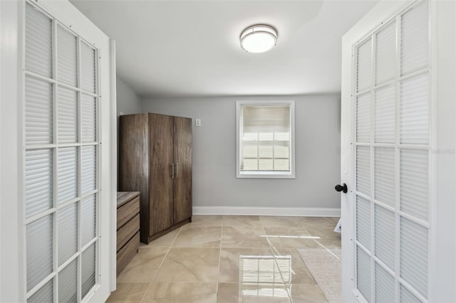bedroom with light tile patterned flooring and baseboards
