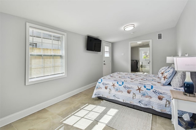 bedroom featuring tile patterned flooring, visible vents, baseboards, and vaulted ceiling