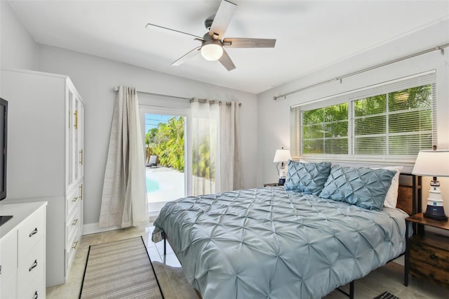 bedroom featuring access to outside, ceiling fan, and multiple windows