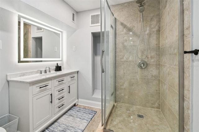bathroom with visible vents, baseboards, a shower stall, and vanity