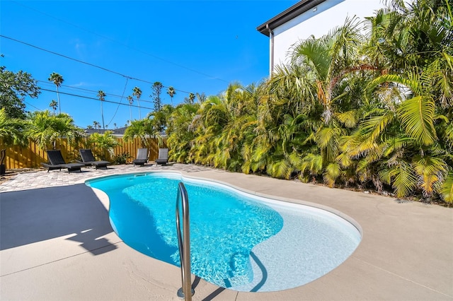 view of swimming pool featuring fence, a fenced in pool, and a patio
