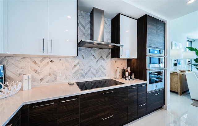 301 1st St S Unit 3004, Saint Petersburg, FL 33701 - kitchen featuring stainless steel double oven, modern cabinets, black electric stovetop, light countertops, and wall chimney exhaust hood