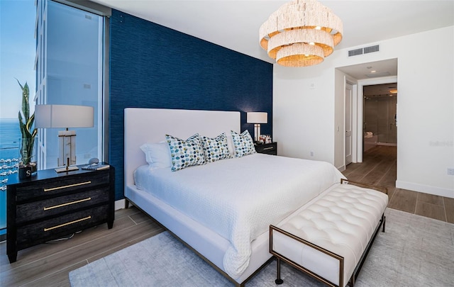 301 1st St S Unit 3004, Saint Petersburg, FL 33701 - bedroom featuring baseboards, an accent wall, wood finished floors, and visible vents