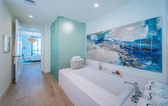 301 1st St S Unit 3004, Saint Petersburg, FL 33701 - ensuite bathroom with wood finished floors, visible vents, connected bathroom, a garden tub, and a stall shower
