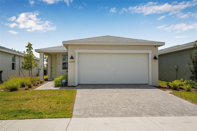 44239 Frontier Dr, Punta Gorda, FL 33982 - view of front of home with an attached garage, a shingled roof, decorative driveway, and stucco siding