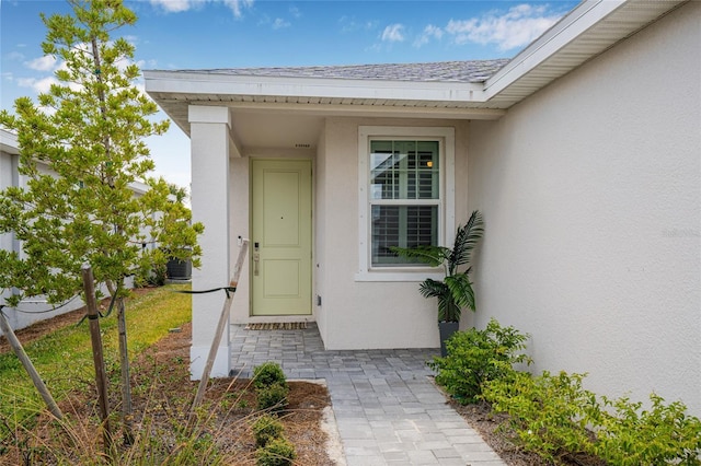 44239 Frontier Dr, Punta Gorda, FL 33982 - view of exterior entry featuring a shingled roof and stucco siding