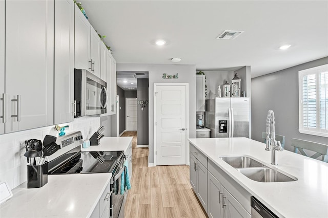 44239 Frontier Dr, Punta Gorda, FL 33982 - kitchen with light wood-type flooring, light countertops, visible vents, appliances with stainless steel finishes, and a sink