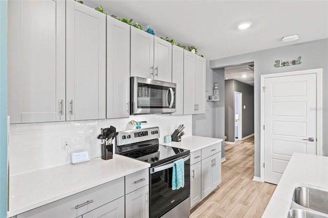 44239 Frontier Dr, Punta Gorda, FL 33982 - kitchen featuring tasteful backsplash, baseboards, light countertops, stainless steel appliances, and light wood-style flooring