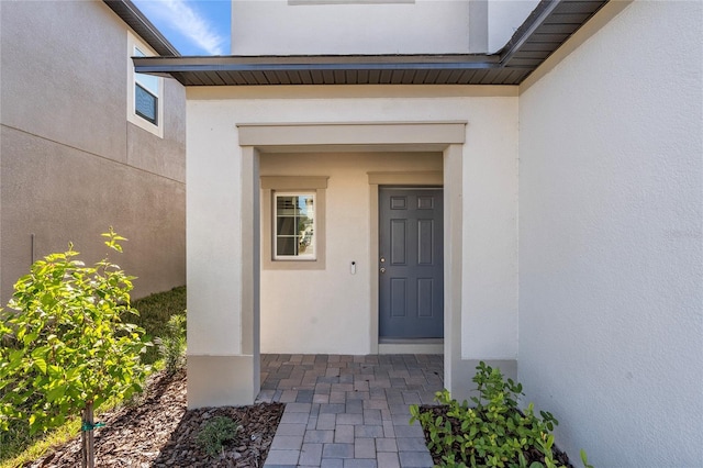 view of exterior entry featuring stucco siding