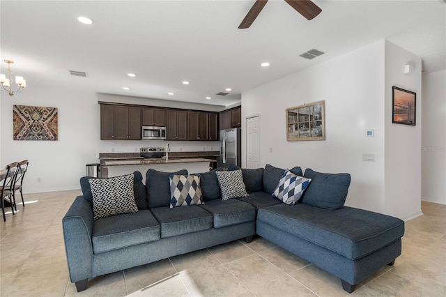 living area featuring recessed lighting, visible vents, ceiling fan with notable chandelier, and baseboards