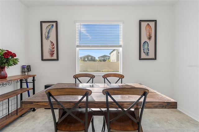 dining area with baseboards and light tile patterned flooring