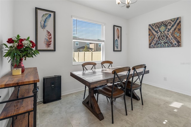 dining space featuring baseboards and an inviting chandelier