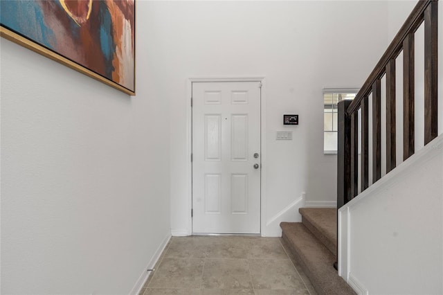 entrance foyer featuring baseboards and stairs
