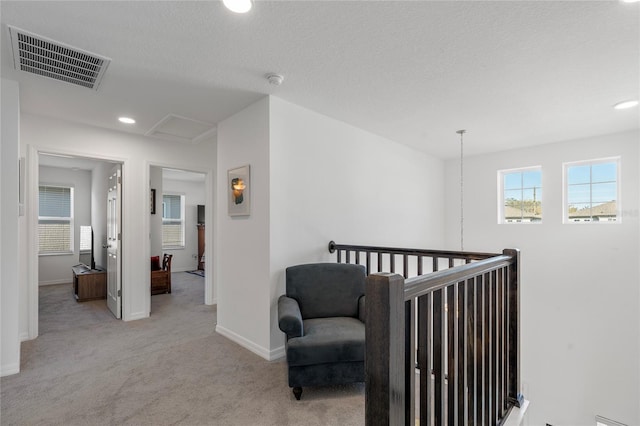 corridor featuring baseboards, recessed lighting, attic access, visible vents, and carpet