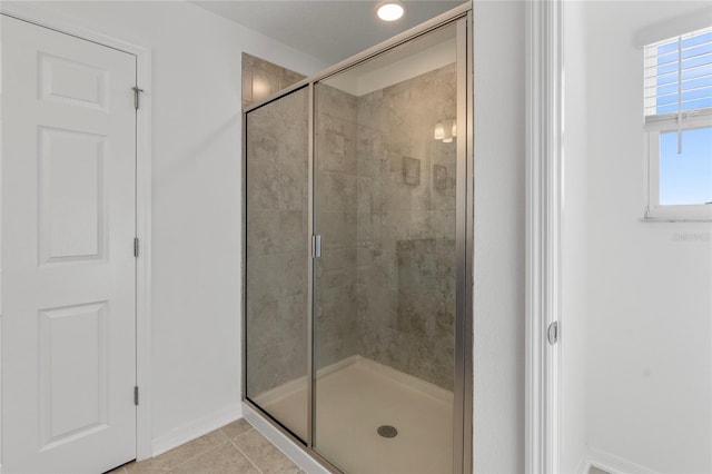 bathroom featuring a shower stall, tile patterned floors, and baseboards