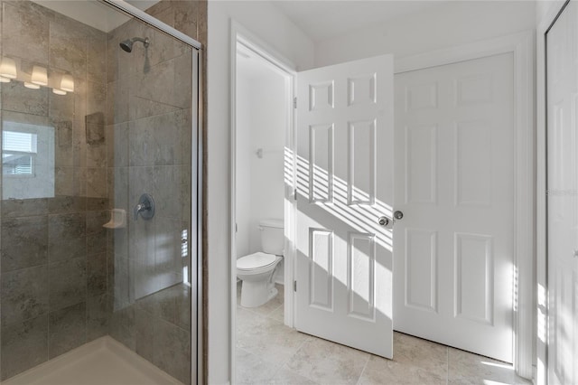 bathroom with toilet and a stall shower