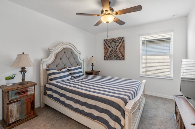 carpeted bedroom featuring baseboards and a ceiling fan