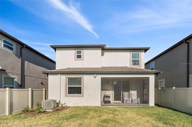 rear view of house featuring stucco siding, central AC unit, a fenced backyard, a sunroom, and a lawn