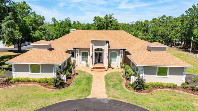 mediterranean / spanish-style home with stucco siding and a front yard