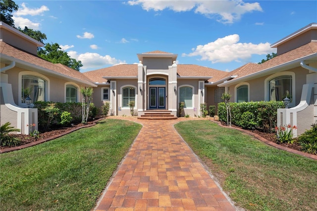 mediterranean / spanish-style house featuring a front lawn and stucco siding