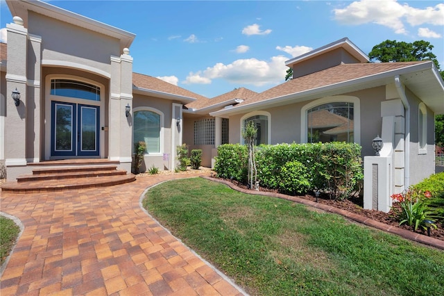 mediterranean / spanish-style home featuring stucco siding and roof with shingles