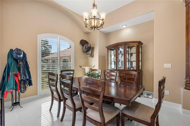 dining space featuring baseboards, a notable chandelier, and light tile patterned floors