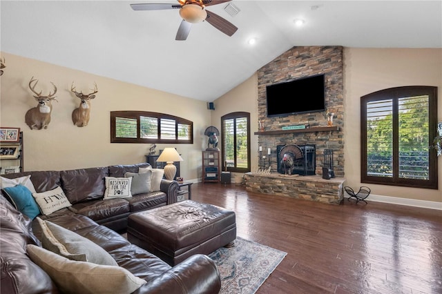 living area with vaulted ceiling, a ceiling fan, a stone fireplace, baseboards, and visible vents