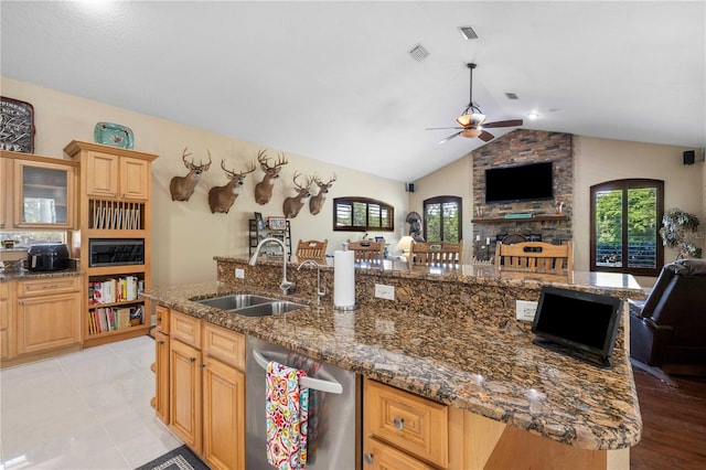 kitchen featuring dishwasher, open floor plan, ceiling fan, and a sink