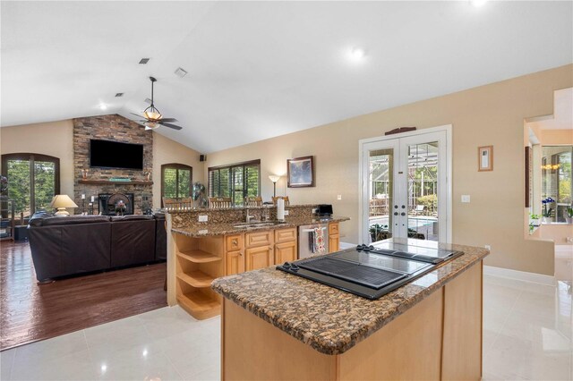 kitchen with black electric cooktop, a center island, light brown cabinetry, french doors, and a ceiling fan