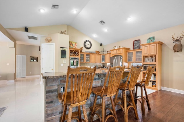 interior space with baseboards, visible vents, and high vaulted ceiling