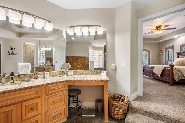 ensuite bathroom featuring baseboards, a ceiling fan, vanity, and ensuite bathroom