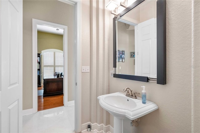 bathroom featuring baseboards and a sink
