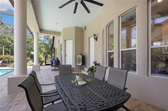 view of patio featuring ceiling fan, a lanai, an outdoor pool, and outdoor dining space