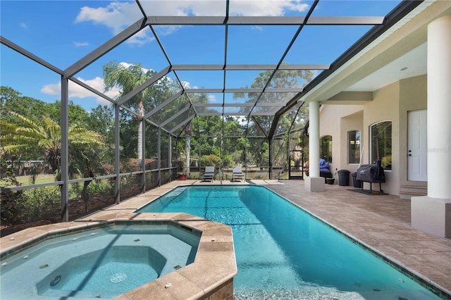 view of pool featuring a lanai, a patio area, a pool with connected hot tub, and area for grilling