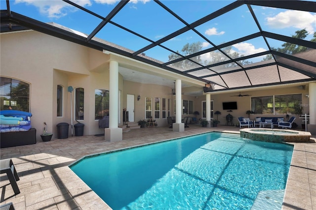 back of property featuring ceiling fan, outdoor lounge area, a patio, stucco siding, and a pool with connected hot tub