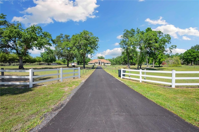 view of street featuring aphalt driveway and a rural view