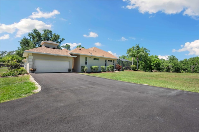 view of front of house featuring glass enclosure, a front lawn, driveway, an attached garage, and stucco siding