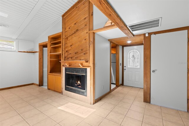 407 Indiana Ave, Crystal Beach, FL 34681 - unfurnished living room with a warm lit fireplace, light tile patterned floors, baseboards, and visible vents