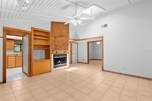 407 Indiana Ave, Crystal Beach, FL 34681 - unfurnished living room with baseboards, a fireplace, a ceiling fan, visible vents, and a skylight