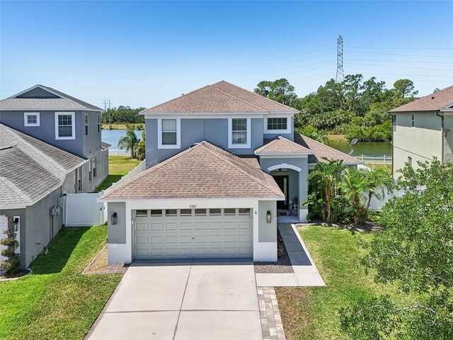 7207 Forest Mere Dr, Riverview, FL 33578 - view of front facade with stucco siding, driveway, roof with shingles, a garage, and a water view