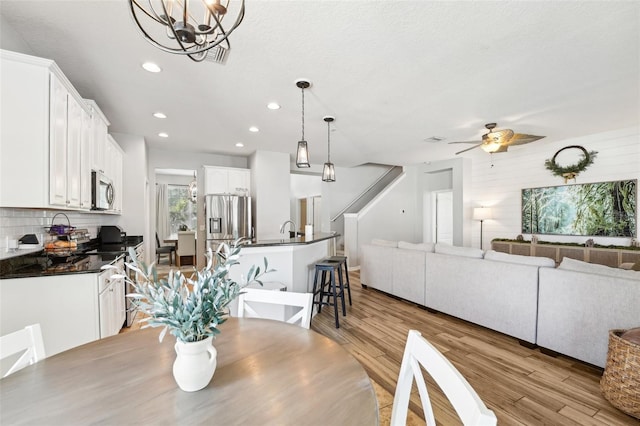 7207 Forest Mere Dr, Riverview, FL 33578 - dining space with stairway, recessed lighting, ceiling fan, light wood-style floors, and a chandelier