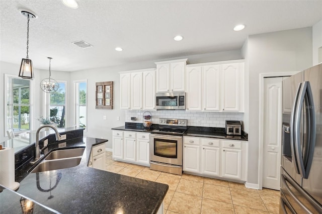 7207 Forest Mere Dr, Riverview, FL 33578 - kitchen with stainless steel appliances, a sink, decorative backsplash, white cabinets, and light tile patterned floors