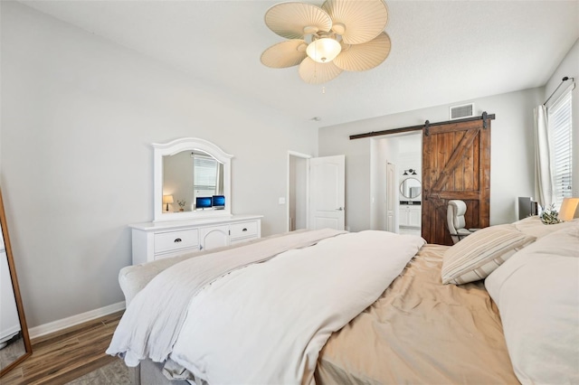 7207 Forest Mere Dr, Riverview, FL 33578 - bedroom with a barn door, wood finished floors, baseboards, a ceiling fan, and ensuite bathroom