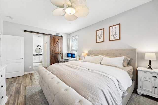 7207 Forest Mere Dr, Riverview, FL 33578 - bedroom featuring light wood-type flooring, a barn door, connected bathroom, and a ceiling fan