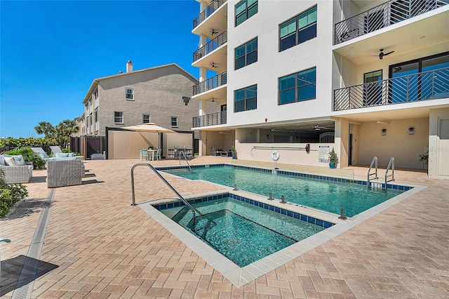 pool featuring a hot tub and a patio area