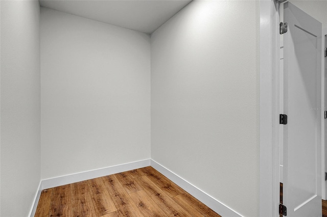 hall with light wood-type flooring and baseboards