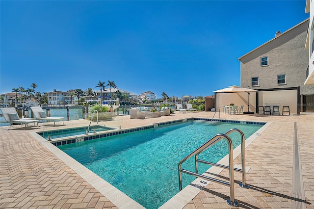 pool with a gazebo, a patio, outdoor lounge area, and a residential view