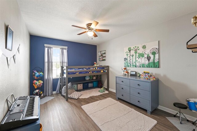 10101 Mangrove Well Rd, Ruskin, FL 33573 - bedroom with a textured ceiling, wood finished floors, baseboards, and a ceiling fan