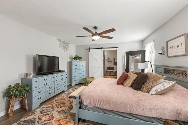 10101 Mangrove Well Rd, Ruskin, FL 33573 - bedroom with a barn door, ceiling fan, baseboards, and wood finished floors